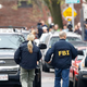 FBI agents comb the streets of Cambridge, Mass., where the writer lives. (Jared Wickerham/Getty Images)